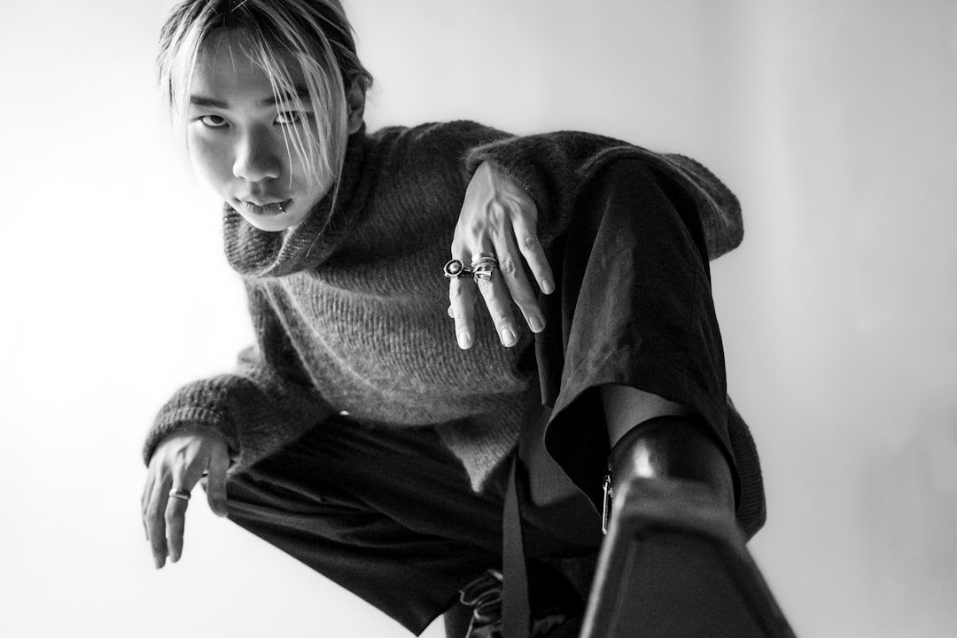 a woman is sitting on a chair with her hand on her hip